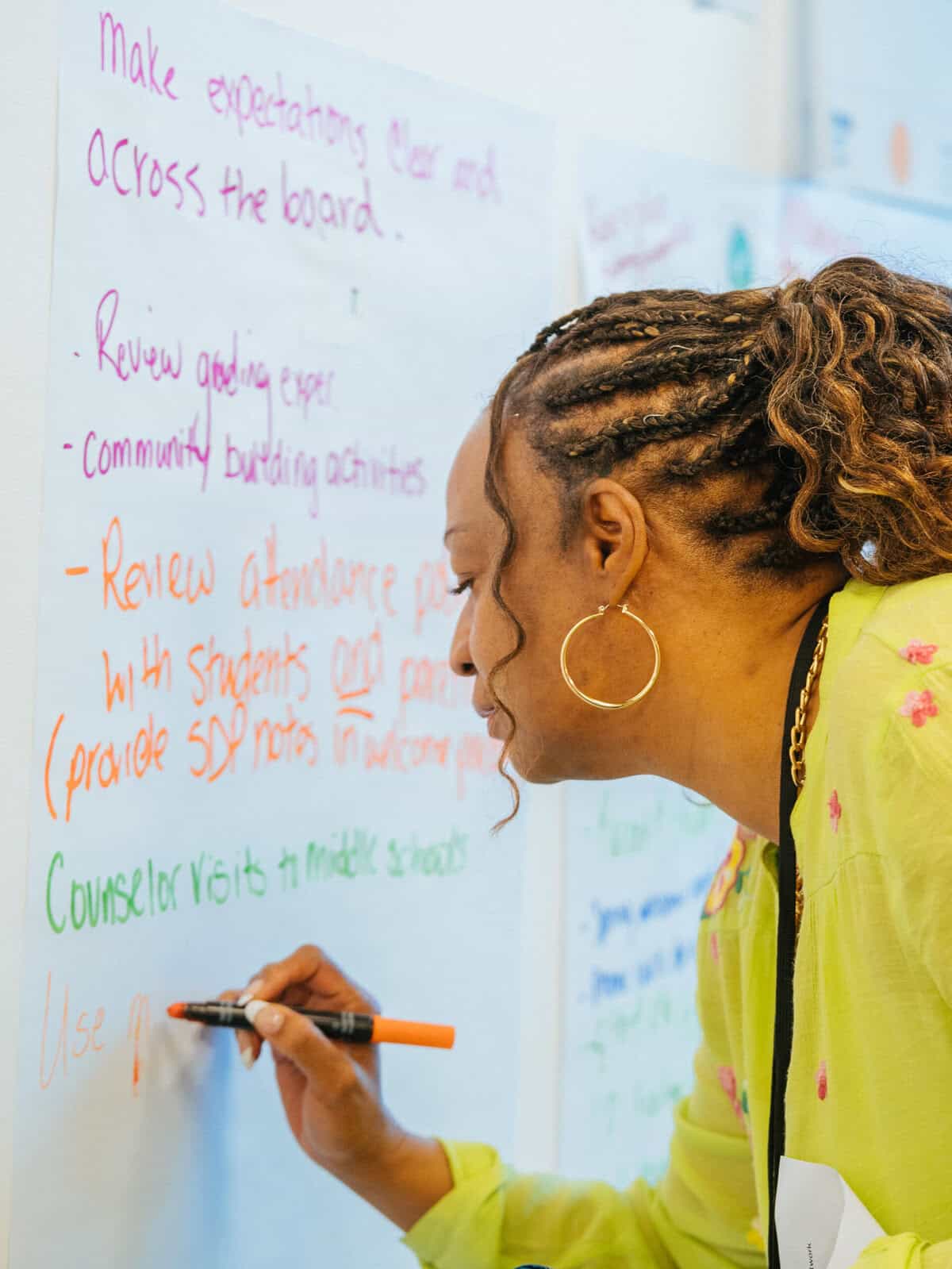 A woman writes on a whiteboard.
