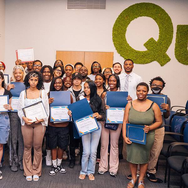Rows of students holding up their graduation certificates.
